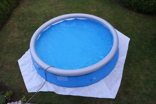 Rund blå badpool med grå toppring, fylld med vatten, kopplad till slang, del av PLANET POOL Combi Set Bottenskyddsmatta för att skydda linern