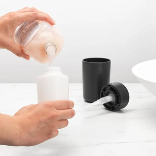 Refilling Brabantia Tvålpump Mörkgrå from clear bottle for a modern bathroom look