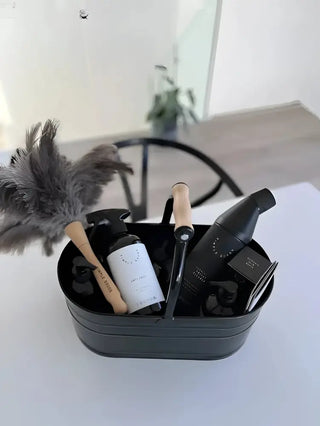 Svart metall rengöringskorg med städprodukter och rengöringsmedel för städning