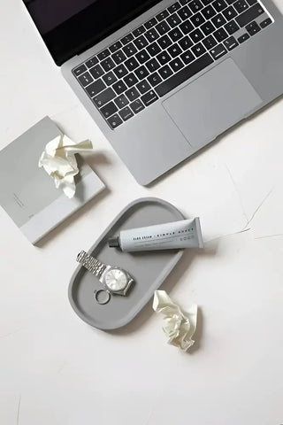 Öppen silverlaptop med mörk skärm på design sverige betongbricka från varje bricka