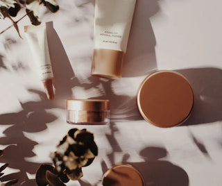 Skönhetsprodukter i matchande varmtonade förpackningar.