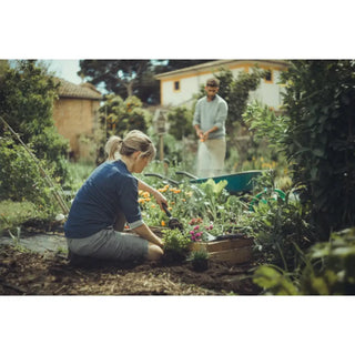 Man och kvinna som använder Fiskars Xact™ planteringsspade i rostfritt stål med skarpa kanter i trädgården