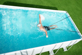 En simmare i en rektangulär pool ovan jord med en motståndslina.
