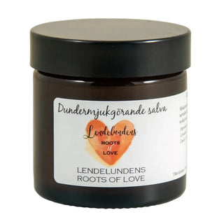 Mörkt bärnstensfärgad glasburk med hudsalva och svart lock.