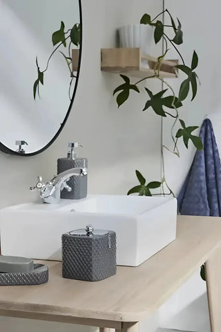 Bild av badrumsblandare med moderna grå tillbehör för praktisk förvaring och städprodukter