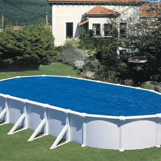 PLANET POOL Termofolie ovala 6,10x3,66 mtr installerad på ovanmarkspool i trädgård. Isolerar effektivt och minskar avdunstning.
