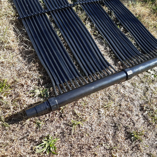 Närbild av solfångare för poolvärme med kopplingssats, visar röranslutning och flexibel montering på mark för optimal soluppvärmning.