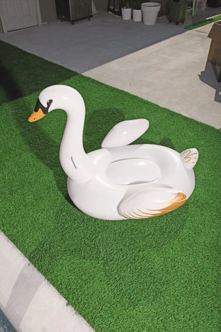 Uppblåsbar Swan flytleksak 1.22m med guldinslag och två luftkammare, placerad på konstgräs vid poolområde.