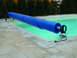 Upprullningsenhet Mobil 210-550 cm med blå termofolie vid pool. Perfekt för enkel hantering och förvaring av poolöverdrag.